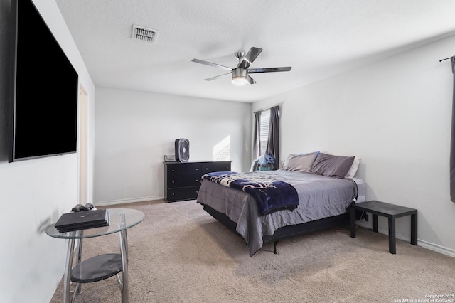 bedroom with a textured ceiling, carpet floors, and ceiling fan