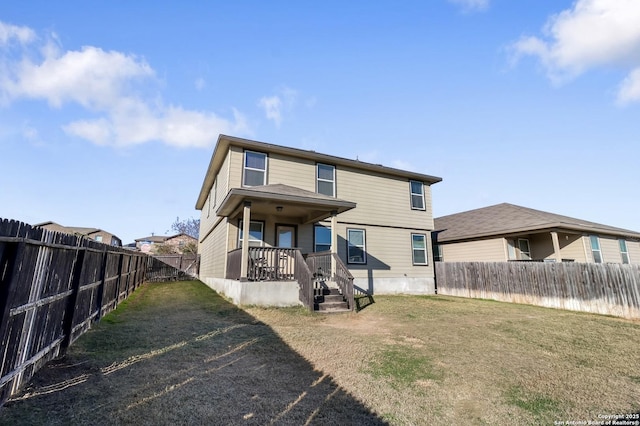 back of property with a porch and a lawn