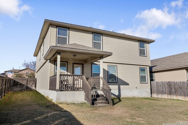 back of property featuring a lawn and covered porch