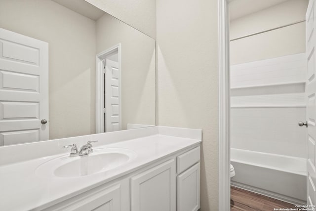 bathroom with toilet, vanity, and hardwood / wood-style floors