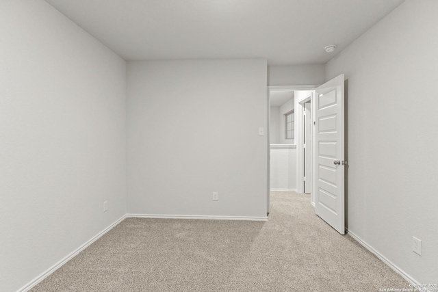 unfurnished room featuring light carpet