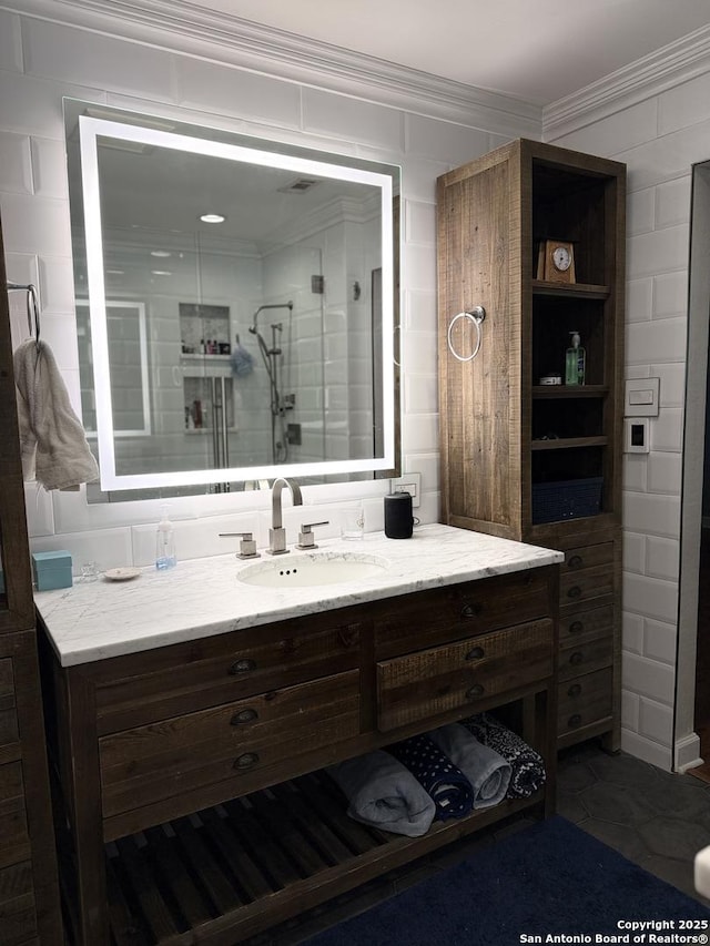 bathroom with vanity, crown molding, and a shower with shower door