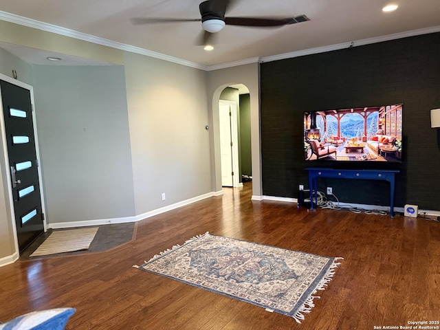 cinema room with wood-type flooring, ceiling fan, and crown molding