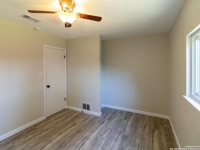 spare room featuring hardwood / wood-style flooring and a healthy amount of sunlight