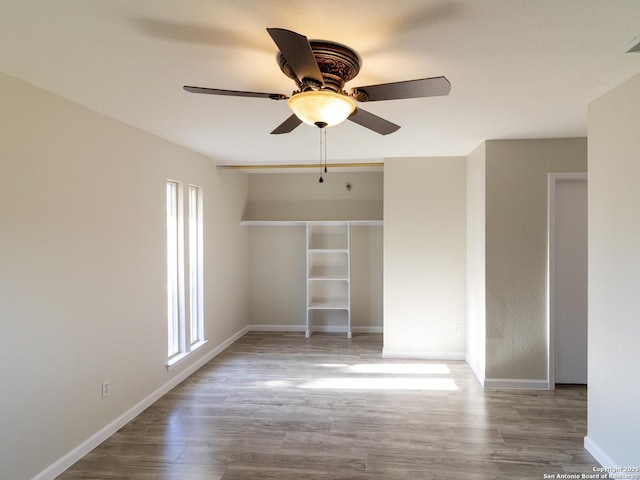 unfurnished bedroom with ceiling fan, a closet, and hardwood / wood-style floors