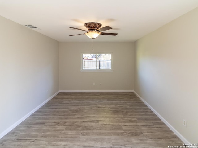 empty room featuring ceiling fan and hardwood / wood-style floors