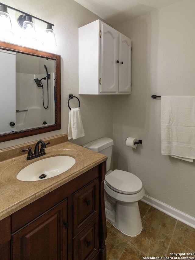 bathroom with walk in shower, vanity, and toilet