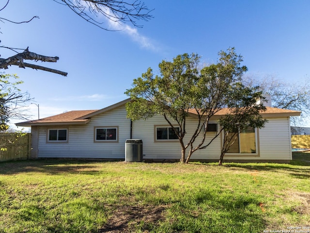 rear view of house with a lawn and central AC unit