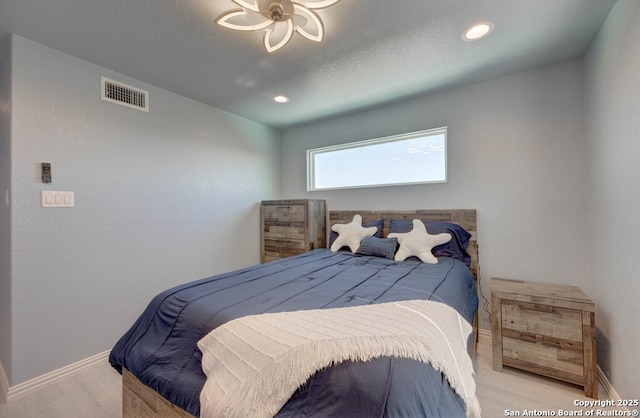 bedroom featuring a textured ceiling and light hardwood / wood-style floors