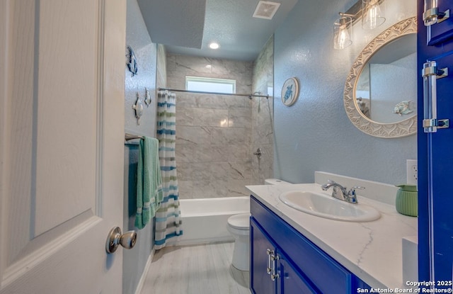 full bathroom featuring shower / tub combo, vanity, a textured ceiling, wood-type flooring, and toilet