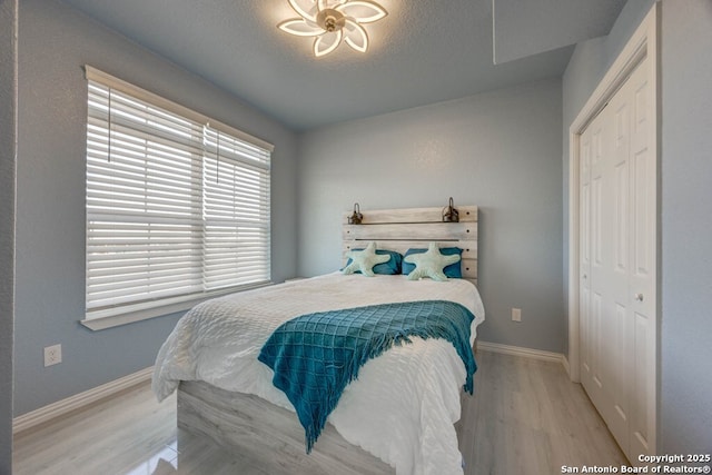 bedroom featuring a closet, a textured ceiling, and light wood-type flooring