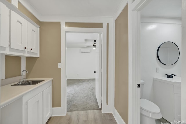 interior space with ceiling fan, ornamental molding, a wall mounted AC, toilet, and hardwood / wood-style flooring