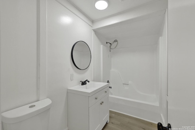 full bathroom featuring hardwood / wood-style floors, toilet, vanity, shower / bathtub combination, and ornamental molding