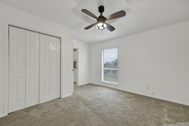 unfurnished bedroom with ceiling fan, a closet, and carpet