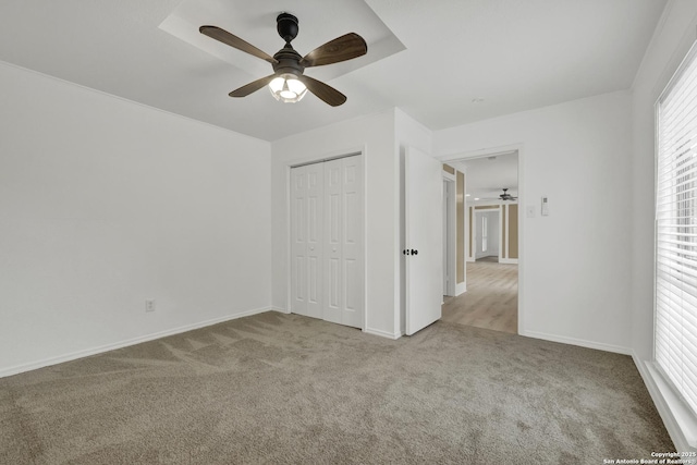 unfurnished bedroom featuring light carpet, a closet, and ceiling fan