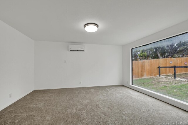 spare room with a wall mounted AC and carpet