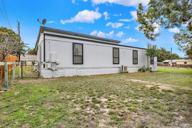 rear view of property with a lawn and central AC unit