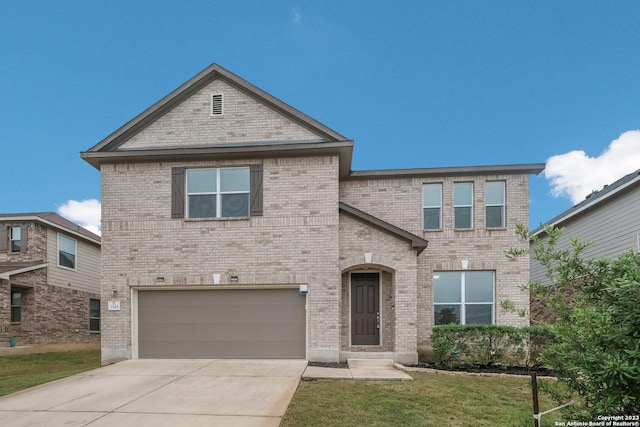 traditional home with an attached garage, driveway, brick siding, and a front yard