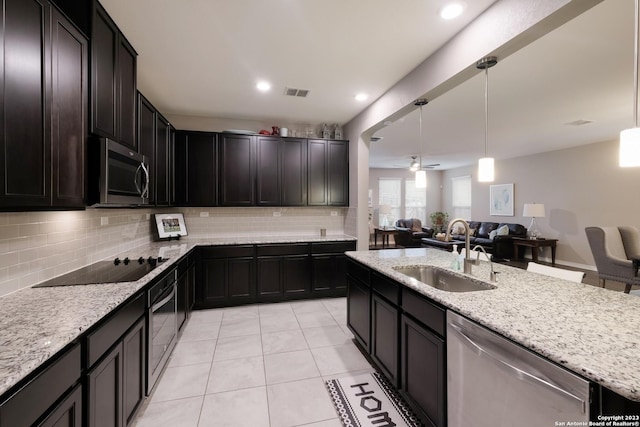 kitchen with hanging light fixtures, stainless steel appliances, a sink, and open floor plan