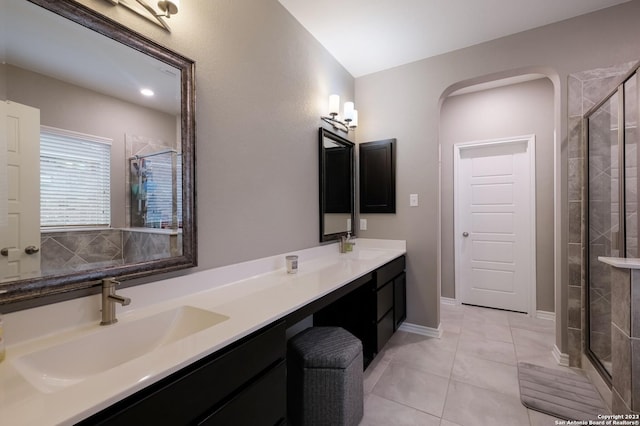 bathroom featuring tile patterned floors, a sink, a shower stall, and double vanity