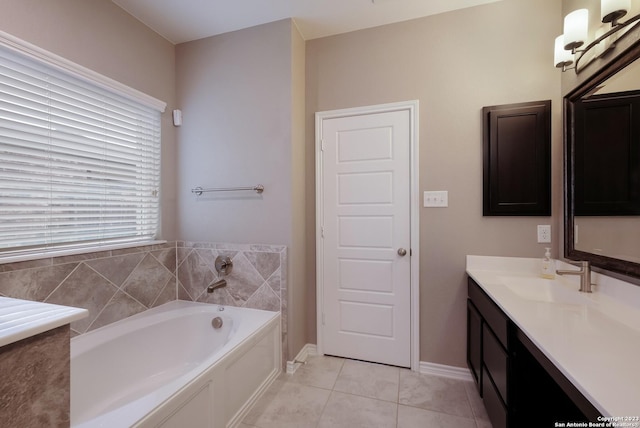 bathroom featuring tile patterned floors, baseboards, a garden tub, and vanity