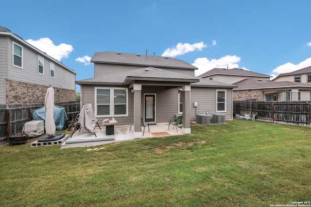 rear view of house featuring a patio, a lawn, and a fenced backyard