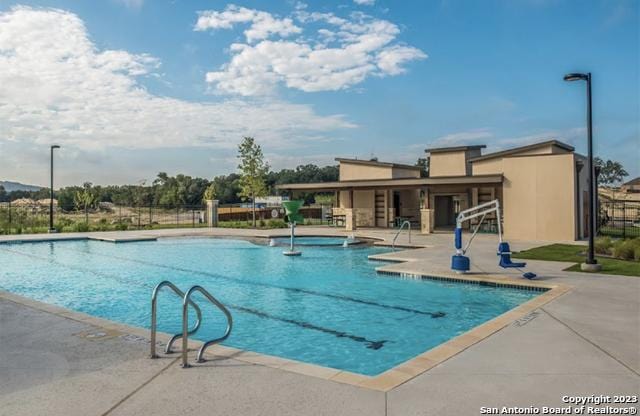 community pool featuring a patio area and fence