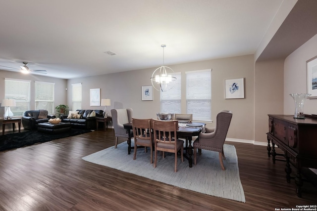 dining room with dark wood-type flooring, visible vents, baseboards, and ceiling fan with notable chandelier