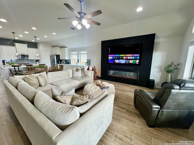 living room with ceiling fan and lofted ceiling