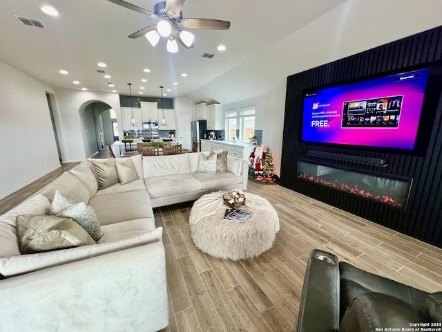 living room featuring ceiling fan and lofted ceiling