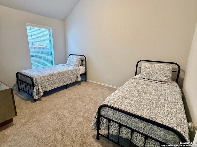 carpeted bedroom with lofted ceiling