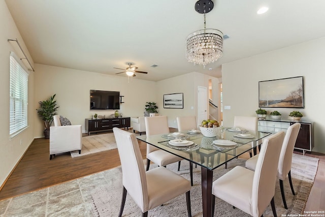 dining room with ceiling fan with notable chandelier and wood-type flooring