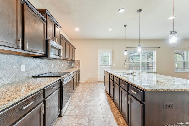 kitchen featuring appliances with stainless steel finishes, tasteful backsplash, a kitchen island with sink, sink, and pendant lighting