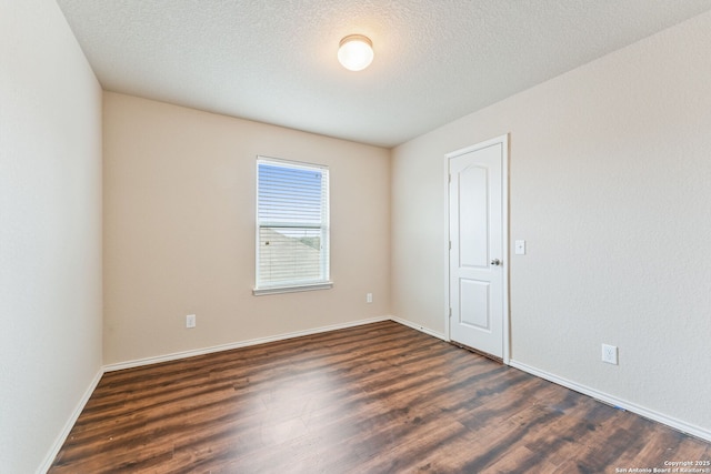 unfurnished room featuring a textured ceiling and dark wood-type flooring