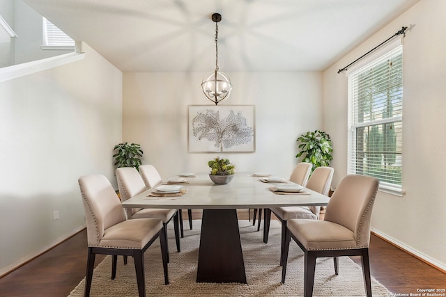 dining area with wood-type flooring and a chandelier