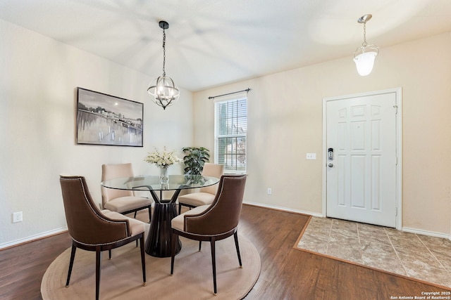 dining space featuring dark hardwood / wood-style flooring and a chandelier