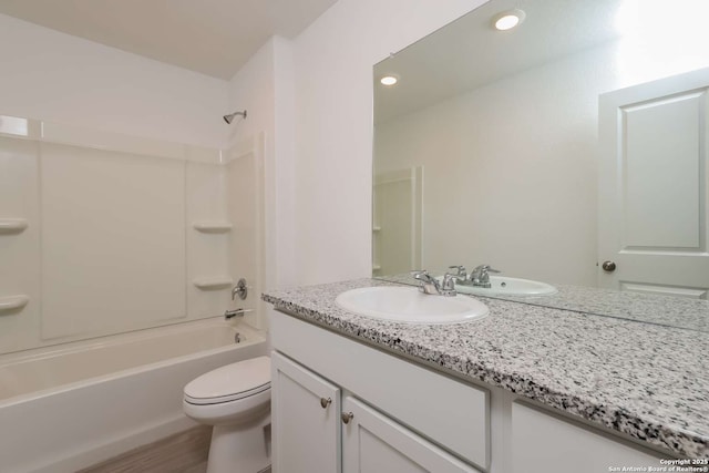 full bathroom with hardwood / wood-style floors, vanity, shower / bath combination, and toilet