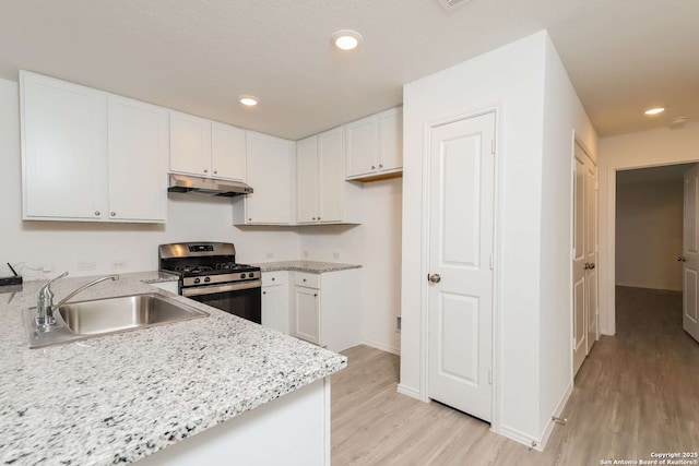 kitchen featuring light stone countertops, sink, stainless steel range with gas cooktop, light hardwood / wood-style flooring, and white cabinets