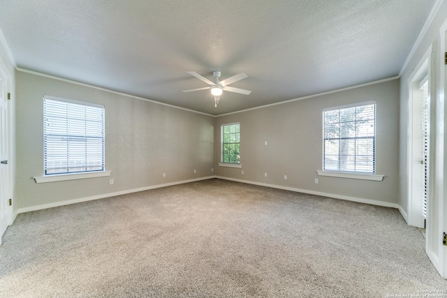 carpeted spare room with a textured ceiling, ceiling fan, and crown molding