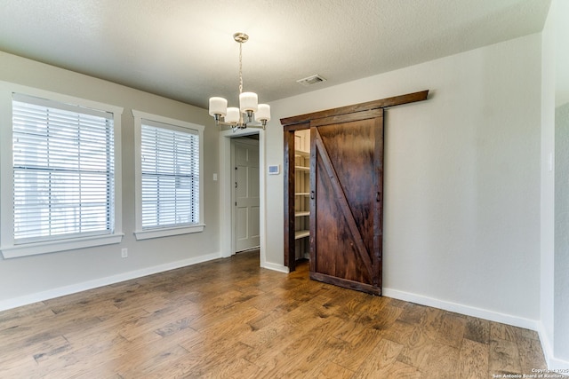 empty room featuring dark wood-type flooring and a chandelier