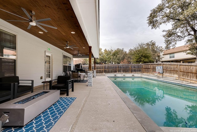 view of pool with a patio area, ceiling fan, and an outdoor living space with a fire pit