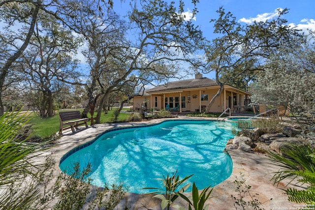 view of pool with an in ground hot tub and a patio