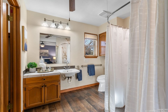 bathroom with wood-type flooring, sink, ceiling fan, and toilet