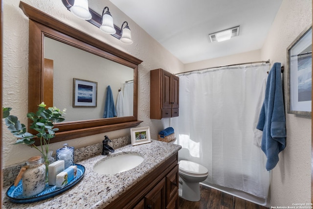 bathroom with vanity, hardwood / wood-style floors, and toilet