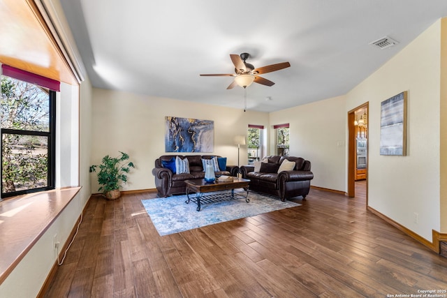 living room featuring dark wood-type flooring and ceiling fan