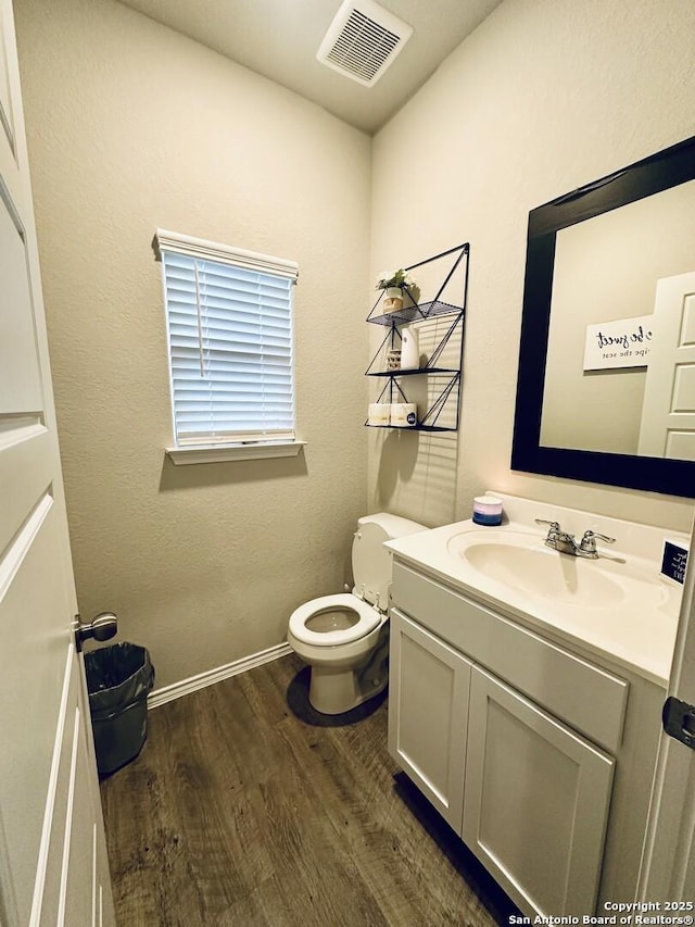 bathroom featuring vanity, wood-type flooring, and toilet