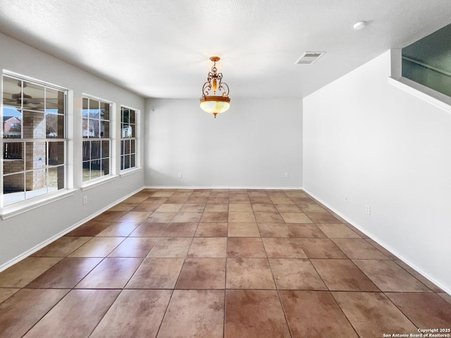 unfurnished dining area featuring a textured ceiling and tile patterned floors