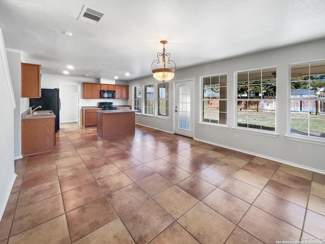 kitchen featuring sink, decorative light fixtures, tile patterned flooring, and black appliances