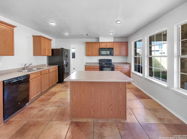 kitchen with sink, light tile patterned flooring, a center island, and black appliances