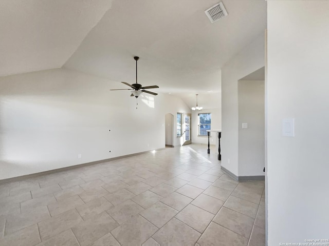 tiled spare room with ceiling fan with notable chandelier and vaulted ceiling